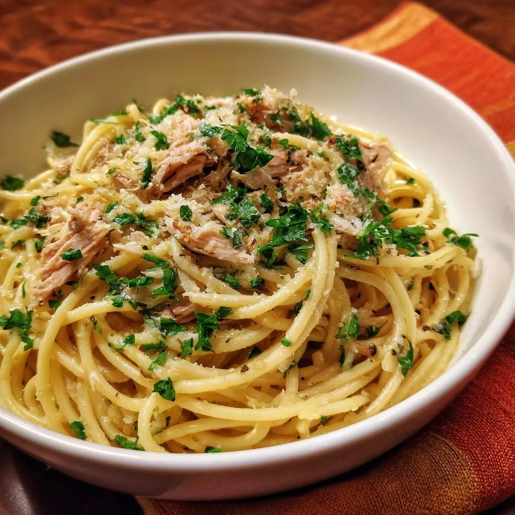 Quick tuna spaghetti topped with fresh parsley and grated cheese, showcasing the texture of the dish.