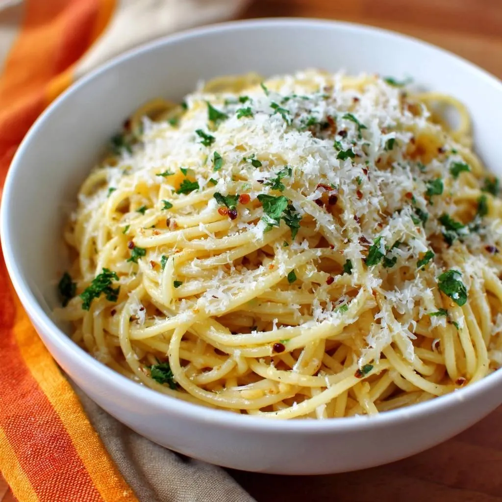 Garlic Parmesan Spaghetti served in a white bowl, generously topped with grated cheese and fresh parsley.