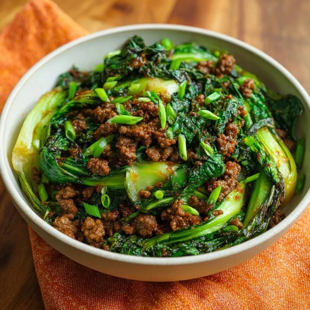 Beef and bok choy stir-fry with crisp texture shown close-up in a white serving bowl.