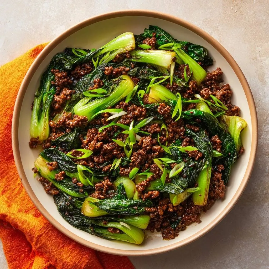 Beef and bok choy stir-fry with crisp texture served in a bowl, viewed from directly above.