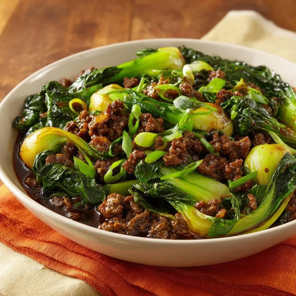 Ground beef bok choy stir-fry served in a white bowl, showcasing tender greens and savory meat with a close-up view.